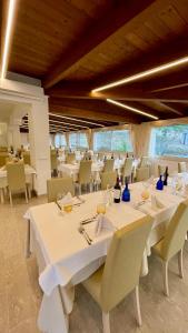 una sala da pranzo con tavoli e sedie bianchi di Hotel Sirena - Servizio spiaggia inclusive a Peschici
