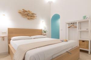- une chambre avec un grand lit et une tête de lit en bois dans l'établissement Aqua Holiday Apartments, à Procida