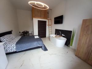 een slaapkamer met een bed, een bad en een wastafel bij Roztoczańskie Apartamenty in Zwierzyniec