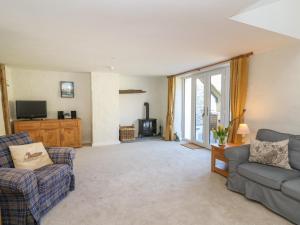 a living room with two couches and a tv at Cattle Tree Cottage in Cardigan
