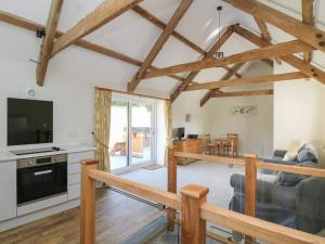 a kitchen and living room with wooden beams at The Parlour in Cardigan