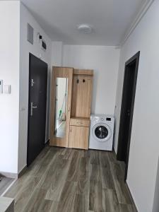 a laundry room with a washing machine and a door at Apartament Cristal in Arad