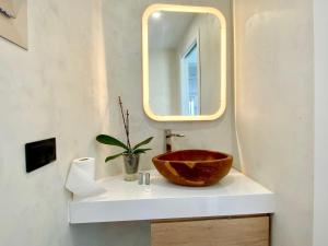 ein Badezimmer mit einer Holztasche auf einem Waschbecken mit einem Spiegel in der Unterkunft Sun golf house in Maspalomas