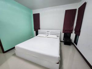 een kleine slaapkamer met een wit bed en 2 ramen bij Phanason Private Home soi 4 in Kathu
