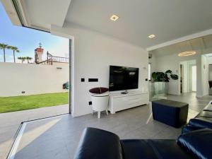 a living room with a large tv and a couch at Sun golf house in Maspalomas