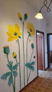 a mural of yellow flowers on a wall at Latte e Menta in Lamporecchio