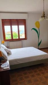 a bedroom with a large bed and a window at Latte e Menta in Lamporecchio