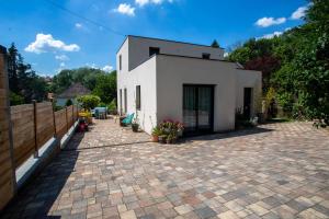ceglane patio z białym budynkiem w obiekcie Maison village - 7 min de Metz centre w mieście Lessy