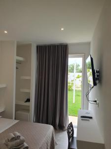 una camera con letto, scrivania e finestra di SeA Beach Home a Torre Lapillo