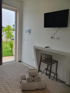 Habitación con escritorio, silla y TV. en SeA Beach Home, en Torre Lapillo