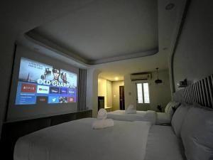 um quarto de hotel com duas camas e uma televisão de ecrã plano em DiscoveryHome2 at Pratunammarket em Bangkok