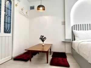um pequeno quarto com uma mesa e uma cama em DiscoveryHome2 at Pratunammarket em Bangkok