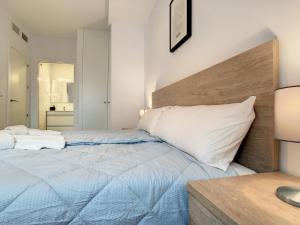 een slaapkamer met een groot bed met een houten hoofdeinde bij Levansur Apartment - 9109 in San Pedro del Pinatar