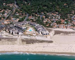Bel appartement en bord de mer avec piscine في لاكانو-أوسيان: اطلالة جوية لمنتجع على الشاطئ