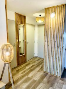 Pokój z przedpokojem z drewnianą podłogą i lustrem w obiekcie Bel appartement en bord de mer avec piscine w mieście Lacanau-Océan