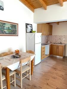 a kitchen with a table and a white refrigerator at Guest House Elisabeta in Përmet