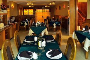 a dining room with tables and chairs with blue table cloth at Casona Plaza Balsa Inn in Puno