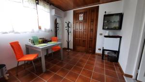 Cette chambre dispose d'un bureau avec des chaises orange et d'une télévision. dans l'établissement Casa Masciò, 