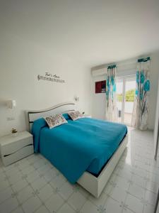 um quarto com uma cama azul num quarto branco em Capri Melody em Anacapri