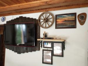 a flat screen tv hanging on a wall with pictures at Wigierska Chatka in Gawrych Ruda