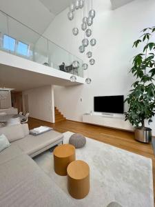 a living room with a couch and a tv at Bodensee Loft in Strandnähe in Lochau