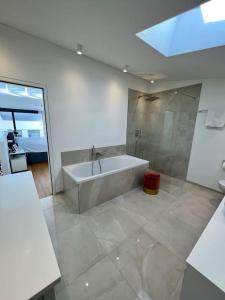 a large bathroom with a tub and a shower at Bodensee Loft in Strandnähe in Lochau