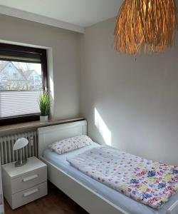 1 dormitorio con cama, ventana y lámpara en Ferienwohnung Lynn, en Büsum
