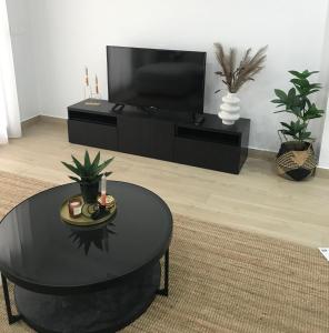 a living room with a black table and a tv at 49 Laguna Beach in Torrevieja