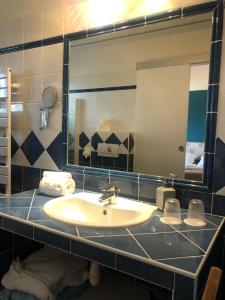 baño con lavabo y espejo grande en Villa Antoline, en Cagnes-sur-Mer