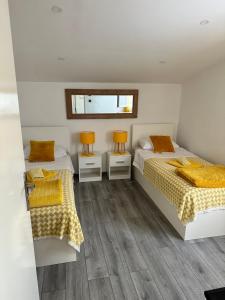 two twin beds in a room with wood floors at Lora in Skradin