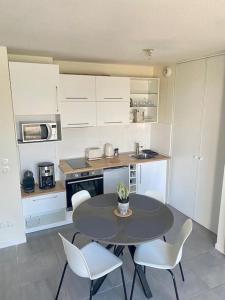 Una cocina con una mesa y sillas en una cocina. en Appartement cosy proche Bordeaux, en Cenon