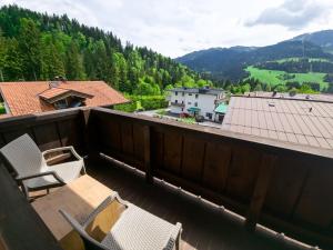 a balcony with chairs and a view of the mountains at Das Alpin - Hotel Garni Guesthouse in Scheffau am Wilden Kaiser