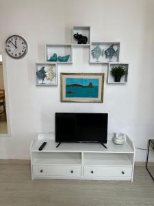 a living room with a tv on a white cabinet at Cami s holidays home mare in Catania