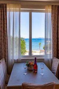 a table with two wine glasses and a view of the ocean at Lanterna Puntamika apt. near beach in Zadar