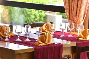 una mesa de madera con copas de vino y servilletas. en AUBERGE d'ARANC en Aranc