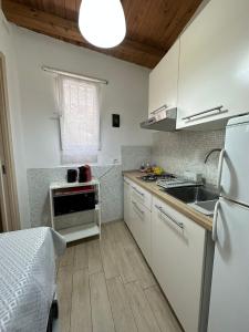 uma cozinha com um frigorífico branco e um lavatório em Cami s holidays home mare em Catânia