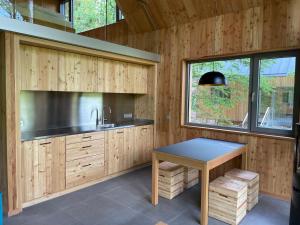 a kitchen with wooden cabinets and a table at Baumwipfelhaus in Annweiler am Trifels +11 photos