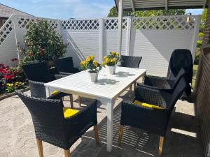 a white table and chairs with flowers on a patio at Kollund Cottage in Kruså +13 photos
