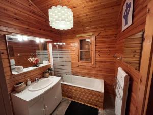 uma casa de banho com um lavatório e uma banheira e um lavatório em Chalet Cosy JMV em Les Angles