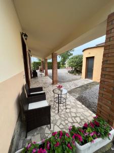 a patio with a table and chairs and flowers at Agriturismo Santa Lucia in Fonteblanda