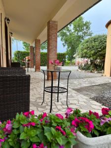 um pátio com uma mesa e algumas flores cor-de-rosa em Agriturismo Santa Lucia em Fonteblanda