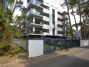 an apartment building with a fence in front of it at VacationClub – Sosnowa 4 Apartament 25 in Mielno