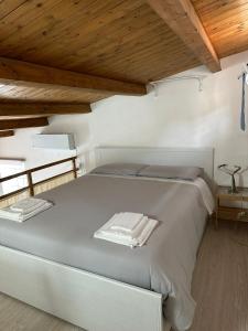 uma cama branca num quarto com tectos em madeira em Cami s holidays home mare em Catânia