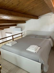 uma cama branca num quarto com tectos em madeira em Cami s holidays home mare em Catânia