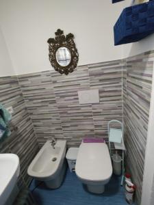 ein Badezimmer mit einem WC, einem Waschbecken und einem Spiegel in der Unterkunft La Nuvola in Sagliano Micca