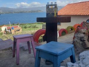 eine Gruppe von Tischen und Stühlen neben einem Wasserkörper in der Unterkunft Cabañas Villas Del Lago in Cuítiva