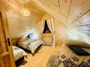 a bedroom with two beds in a wooden cabin at Osada Foltynówka in Soblówka