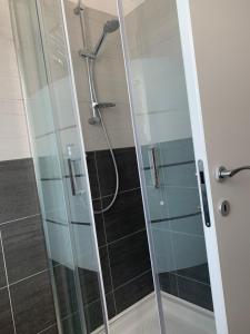 a shower with a glass door in a bathroom at PeschieraView Flat x4 in Peschiera del Garda