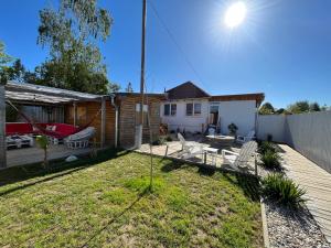 a backyard with a deck and a house at Aloha Apartman in Rakamaz