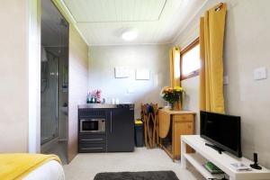 Habitación pequeña con cocina y TV. en Ocean View 8 - 1 Bedroom Chalet - Llanrhidian, en Llanrhidian